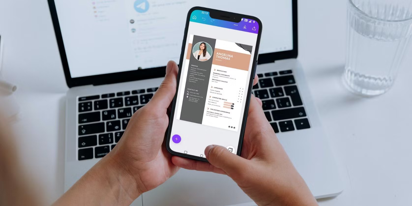 اپ Canva روی گوشی جلوی لپتاپ